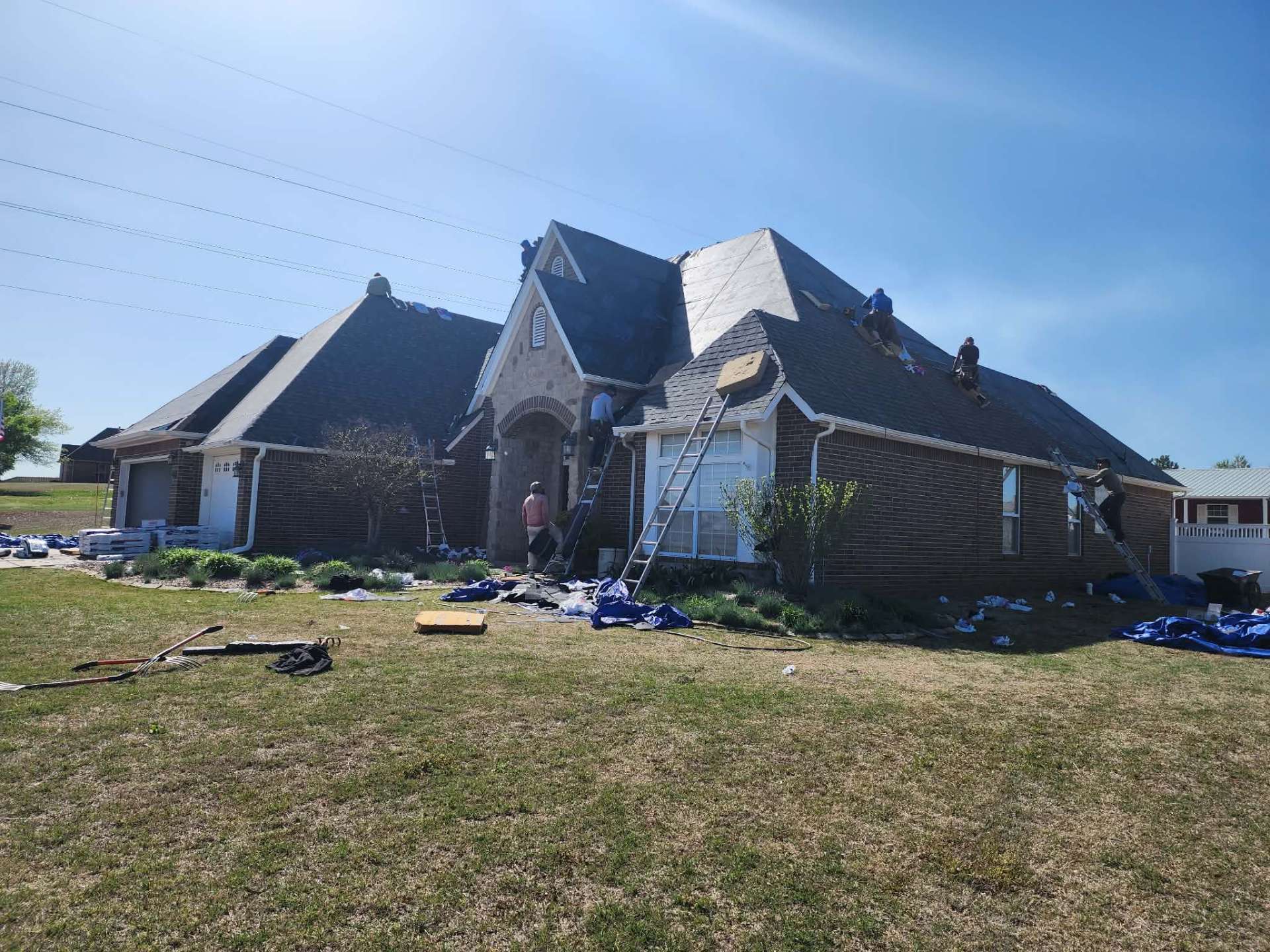 Crew working multiple sections of large residential roof