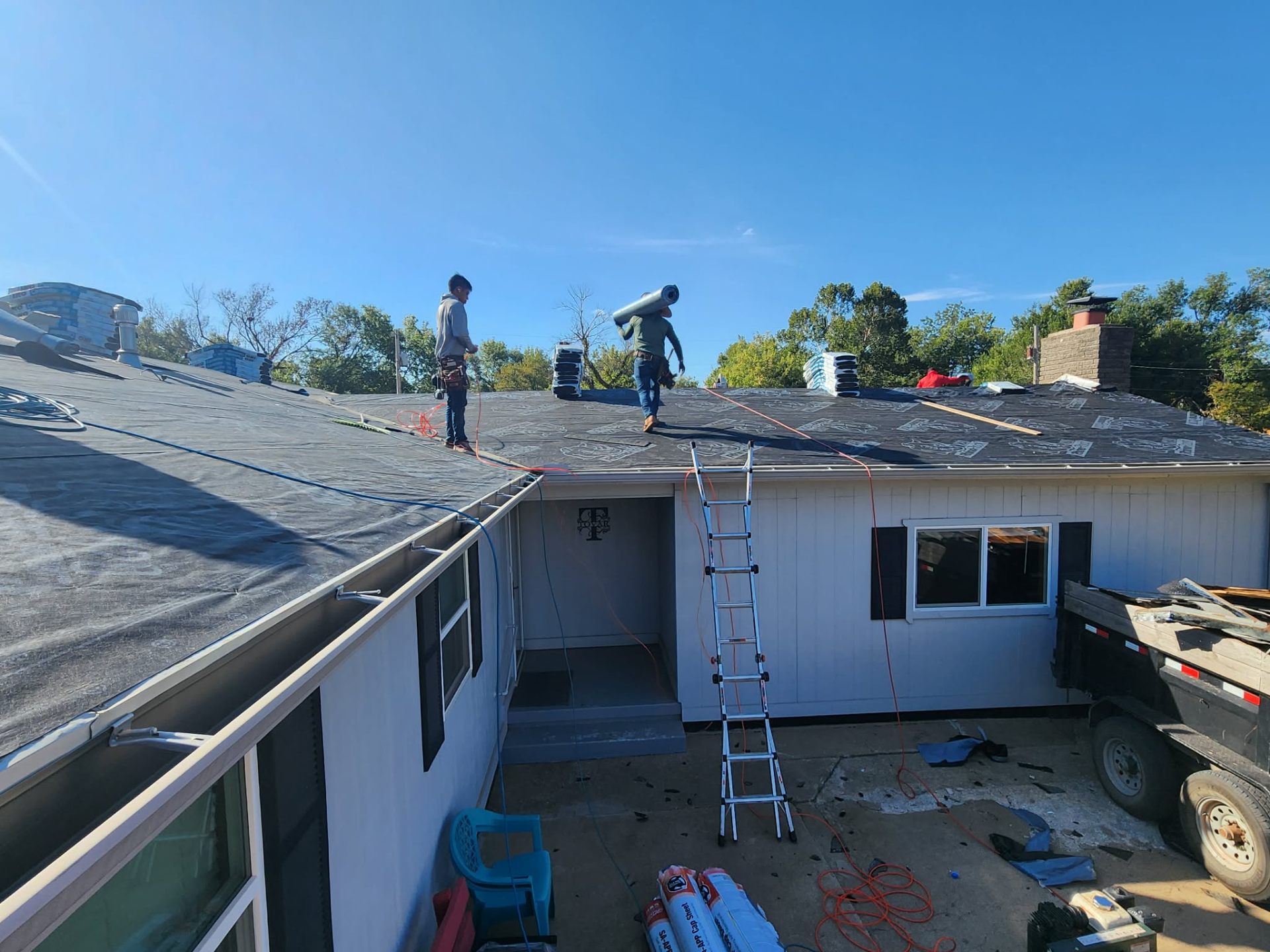 Crew installing synthetic underlayment on full residential tear-off
